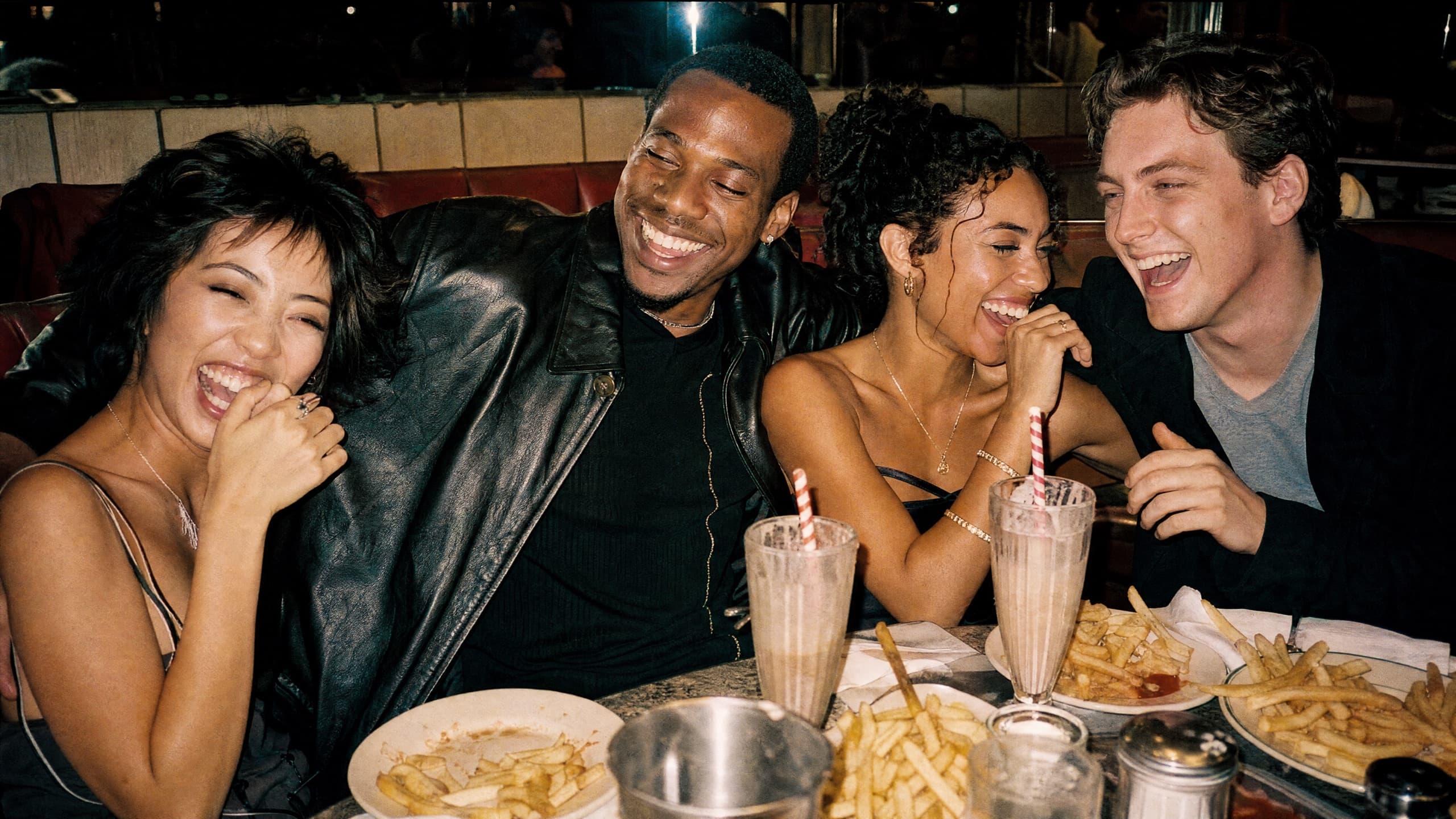 Friends talking over dinner in a diner booth